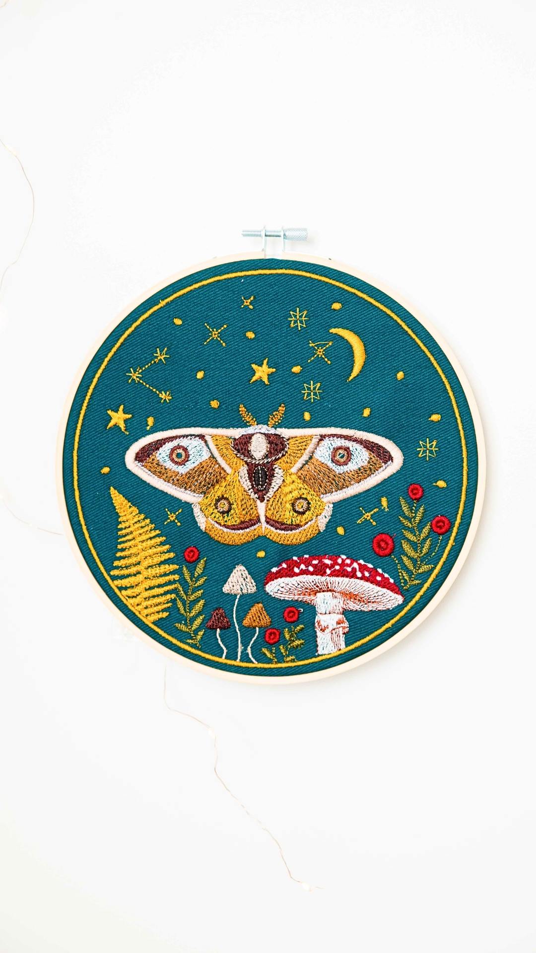 Haft w tamborku, magiczna ćma na tle nieba