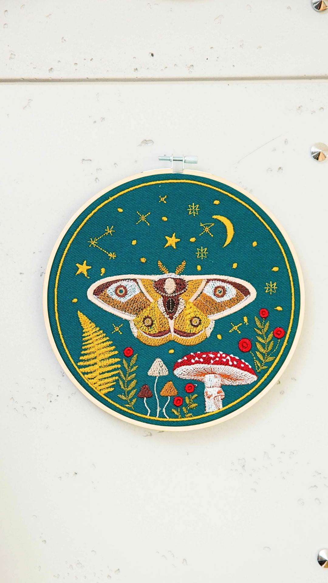 Haft w tamborku, magiczna ćma na tle nieba