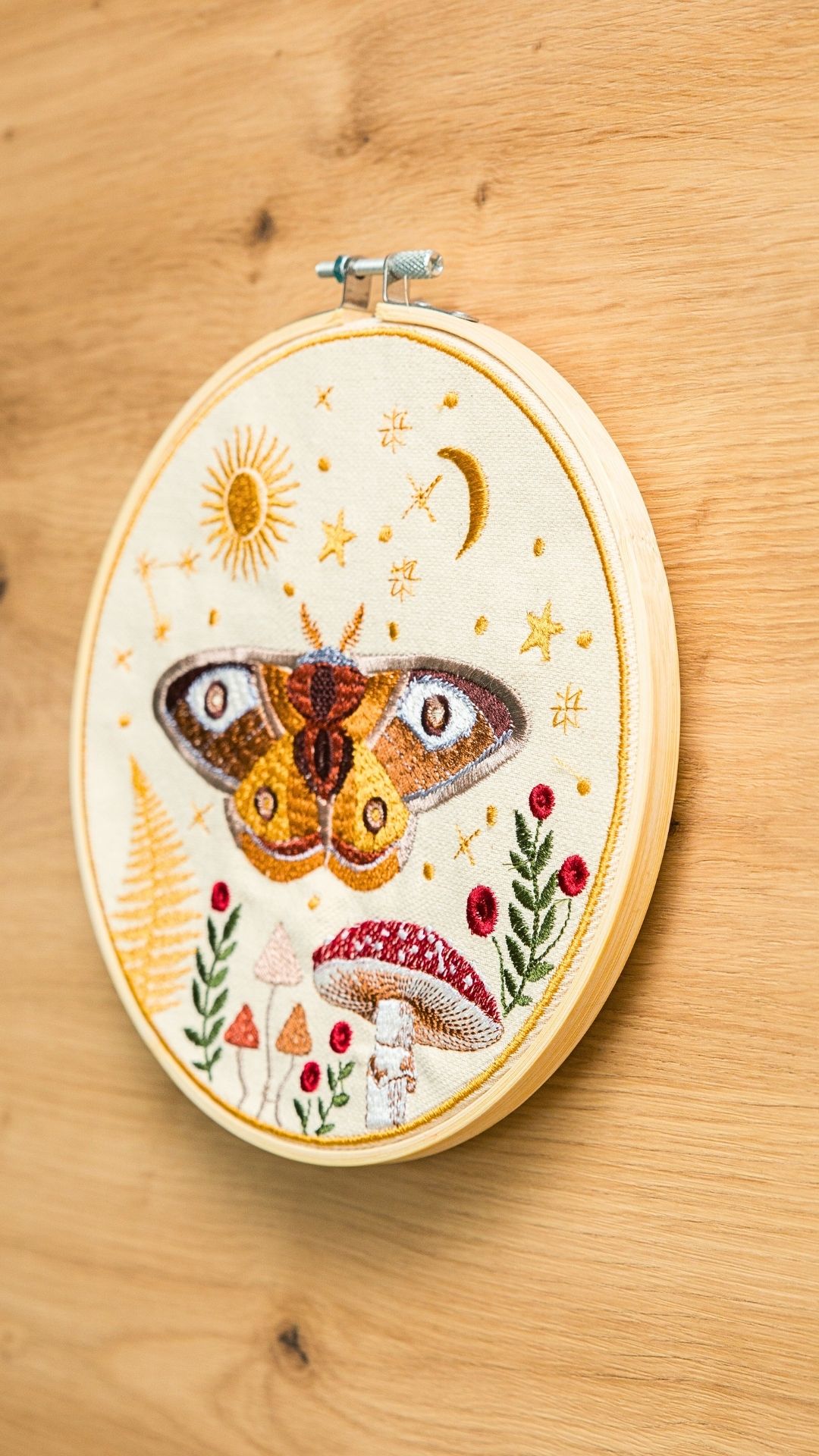 Haft w tamborku, magiczna ćma na tle nieba