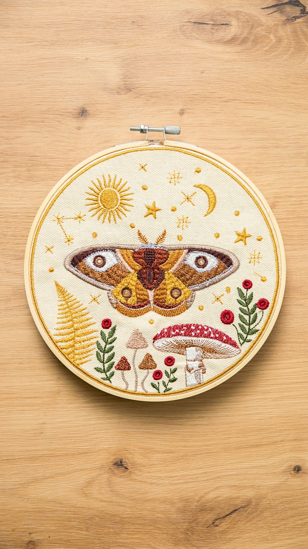 Haft w tamborku, magiczna ćma na tle nieba